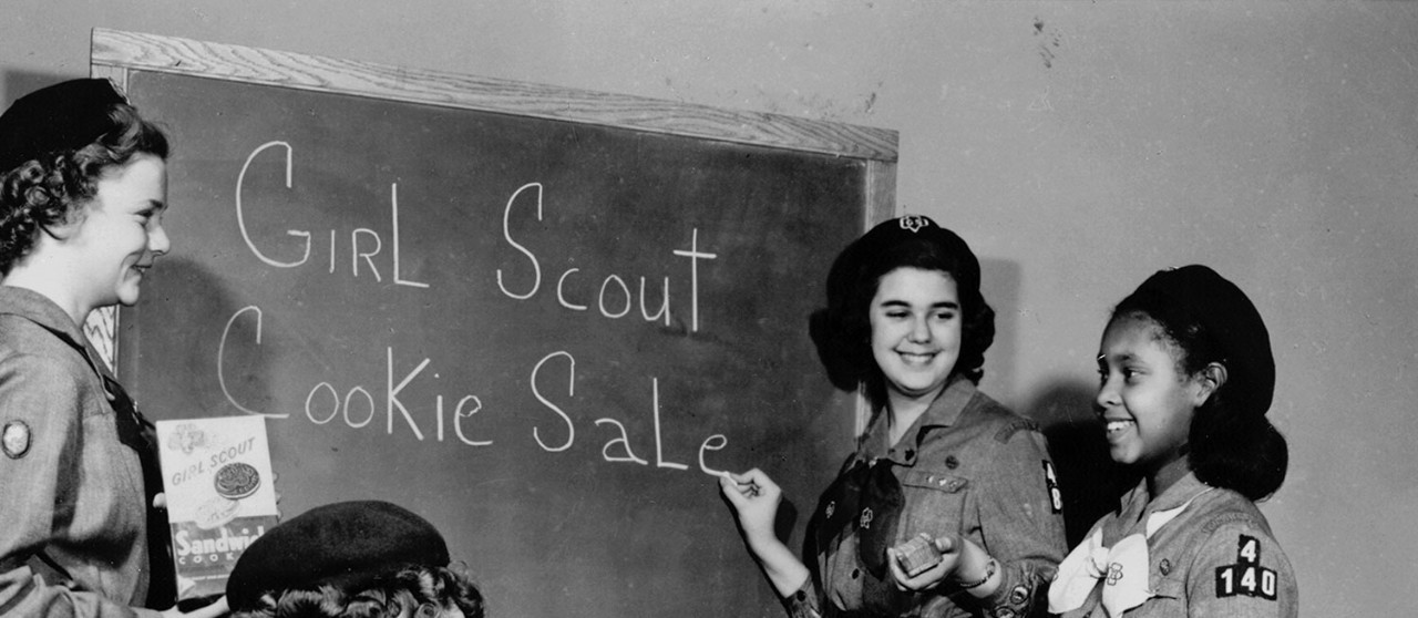 Girl Scouts at blackboard planning a Girl Scout Cookie Sale